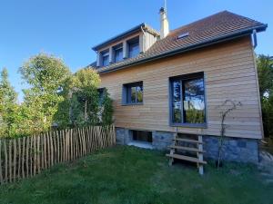 a house with a wooden fence and a ladder at Villa Jules Grand Gîte in Agon Coutainville