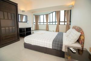 a bedroom with a bed and a desk and a window at Sri Sayang Seaview Holiday Home in Batu Ferringhi