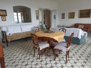 sala de estar con mesa, sillas y sofá en Poggio dei sogni, en Rapallo