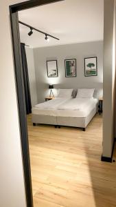 sypialnia z białym łóżkiem i drewnianą podłogą w obiekcie Zajazd Valentino / Listopadowa 55 w mieście Tomaszów Lubelski