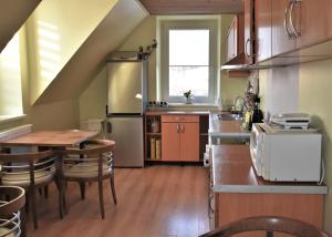 a kitchen with a table and a sink and a refrigerator at Guest House Gero Vėjo Namai in Klaipėda