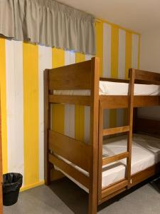 フィゲイラ・ダ・フォズにあるMeeting Hostelのストライプ壁の客室で、二段ベッド2組が備わります。