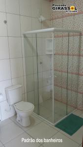 a bathroom with a toilet and a shower at Pousada Girassol da Ferrugem in Garopaba