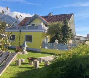ヘルマゴルにあるFerienwohnung Wittenburgの庭にベンチのある黄色い家