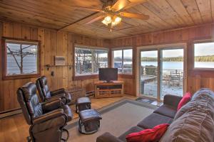 sala de estar con sofá y TV en Charming Lakefront Cabin with Deck and Fire Pit!, en Newport