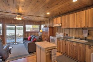 a kitchen and living room of a cabin with a couch at Charming Lakefront Cabin with Deck and Fire Pit! in Newport