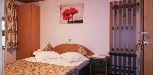 - une chambre avec un lit et une photo sur le mur dans l'établissement Cabana Moieciu, à Moieciu de Sus