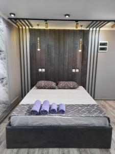 łóżko w pokoju z fioletowymi poduszkami w obiekcie Люкс академика сатпаева 19 w mieście Pawłodar