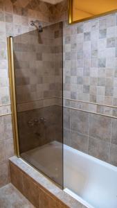 een douche met een glazen deur in een badkamer bij Piedras Doradas Hotel y Spa in Valeria del Mar