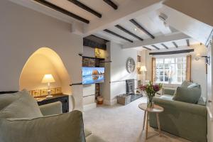 a living room with a couch and a tv at Oyster Catcher Cottage in Brixham