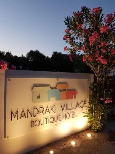 a sign for a marriott village boutique hotel at Mandraki Village Boutique Hotel in Koukounaries