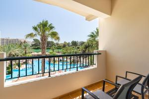 a balcony with chairs and a view of the pool at 3HB Guarana - All Inclusive in Albufeira