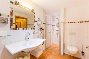 La salle de bains est pourvue d'un lavabo et d'une douche. dans l'établissement Hotel Engel - Familotel Hochschwarzwald, à Todtnauberg