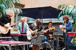 a group of people playing music under an umbrella at City Backpackers Hostel in Stockholm