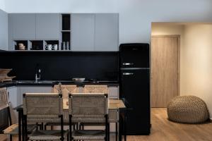 a kitchen with a table and a black refrigerator at Macrame Luxury Suites in Tríkala