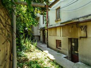 an alley with an old building next to a house at Exquisite 1BR Flat close to city center in Bucharest