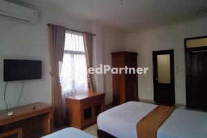 a hotel room with two beds and a television at Hotel Abna Sangatta Mitra RedDoorz in Sengata