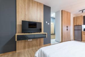 a bedroom with a flat screen tv on a wall at Daisy resort in Novi Sad