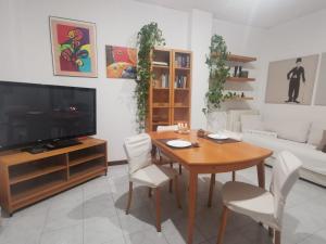 sala de estar con mesa de madera y TV en Appartamento Navigli, en Milán