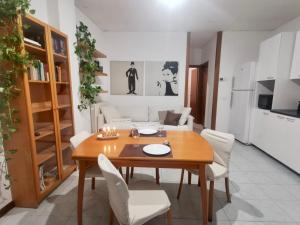 comedor con mesa de madera y sillas blancas en Appartamento Navigli, en Milán