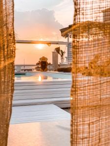 a swimming pool with the sunset in the background at Playa del Mar - Adults Only in Monopoli