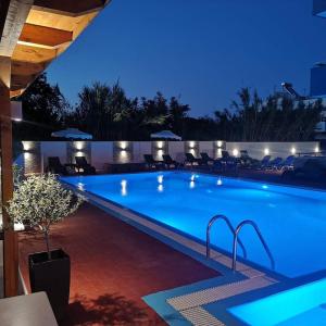 uma grande piscina à noite com luzes em Platoni Elite em Ialyssos