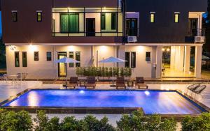 uma piscina em frente a uma casa à noite em Velaa pool villa em Ban Khung Kraben