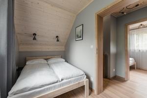 sypialnia z łóżkiem z drewnianym zagłówkiem w obiekcie SZARE DOMKI Szczawnica w mieście Szczawnica