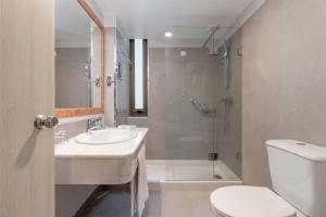 
a bathroom with a toilet, sink, and shower at Enotel Magnólia in Funchal
