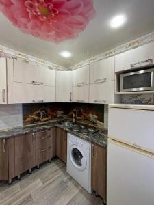 a kitchen with a washing machine and a washer at Лермонтова 91 in Pavlodar