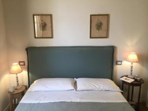 un lit avec une tête de lit verte et deux lampes dans l'établissement Oliveta del Verde Appartamento con Grande Giardino 500mt dal Centro, à Sienne