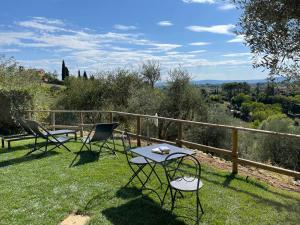 a table and chairs sitting on the grass at Oliveta del Verde Appartamento con Grande Giardino 500mt dal Centro in Siena