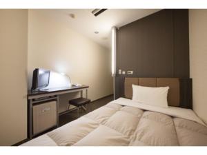 a bedroom with a bed and a desk with a television at R&B Hotel Otsuka Eki Kitaguchi - Vacation STAY 40485v in Tokyo