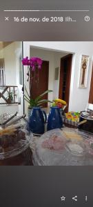una mesa con dos jarrones azules y flores en ella en A Casa Bella - Guesthouse, en Ilhabela
