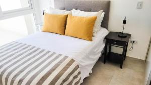 um quarto com uma cama com almofadas amarelas e uma mesa em Poas - Alquiler temporario em Santa Rosa