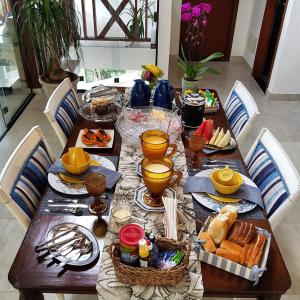 une table en bois avec de la nourriture sur le dessus dans l'établissement A Casa Bella - Guesthouse, à Ilhabela