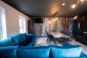 a living room with a blue couch and a table at Sallow Tree House Self Catering in Selby