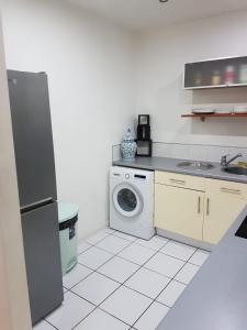 uma cozinha com um frigorífico e uma máquina de lavar roupa em Leicester River Building Ensuite King size Luxury Bed em Leicester