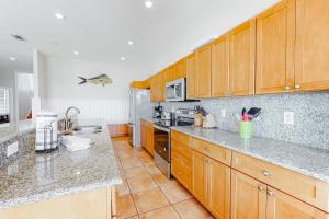 a kitchen with wooden cabinets and granite counter tops at Lund - Nordic Villas in Orange Beach