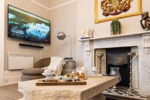 un soggiorno con camino e TV di The Regal Apartment a Royal Tunbridge Wells