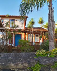 uma casa com palmeiras em frente em Vila das Artes Chales em Lavras Novas