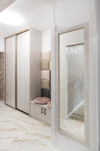 ein Ankleidezimmer mit einem Spiegel und einer Tür in der Unterkunft GDAŃSK CENTRUM Stylowy Apartament in Danzig