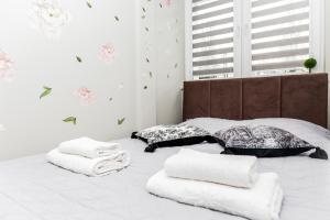 ein Schlafzimmer mit einem Bett mit Handtüchern darauf in der Unterkunft GDAŃSK CENTRUM Stylowy Apartament in Danzig