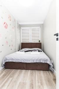 ein Schlafzimmer mit einem großen Bett und Holzboden in der Unterkunft GDAŃSK CENTRUM Stylowy Apartament in Danzig