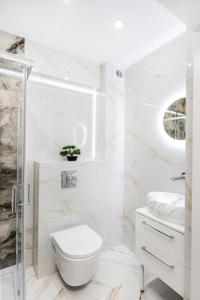 ein weißes Bad mit einem WC und einem Waschbecken in der Unterkunft GDAŃSK CENTRUM Stylowy Apartament in Danzig