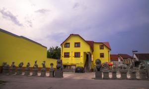 una casa gialla con una recinzione di fronte di Mr.Liao Hotel a Himberg
