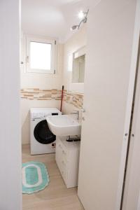 a bathroom with a sink and a washing machine at B&B da Mamma Anna in Matera