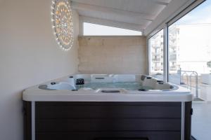 a bathroom with a jacuzzi tub with a window at Ada Suites & Spa in Lecce