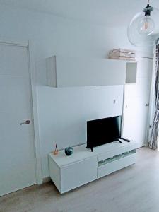 a living room with a flat screen tv on a white cabinet at Apartamento El Príncipe in Peñíscola