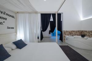 - une chambre avec un lit blanc et une baignoire dans l'établissement Ada Suites & Spa, à Lecce